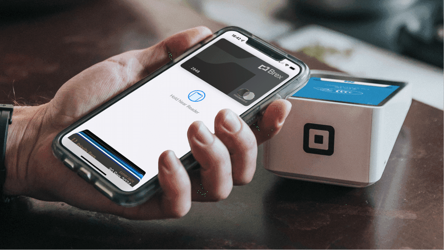 A man holding a phone and tapping to pay