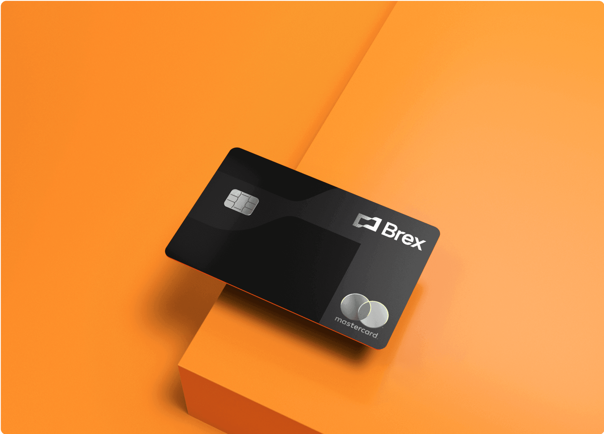 A Brex credit card on the edge of an orange table. 